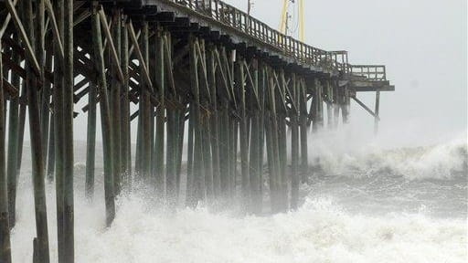 Waves pound Carolina Beach pier in Carolina Beach, N.C. as...