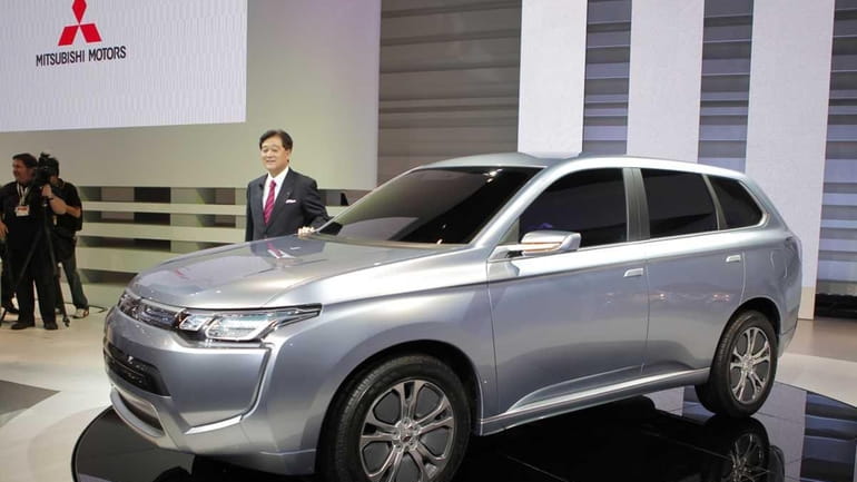 Mitsubishi Motors Corp. President Osamu Masuko poses with concept car...