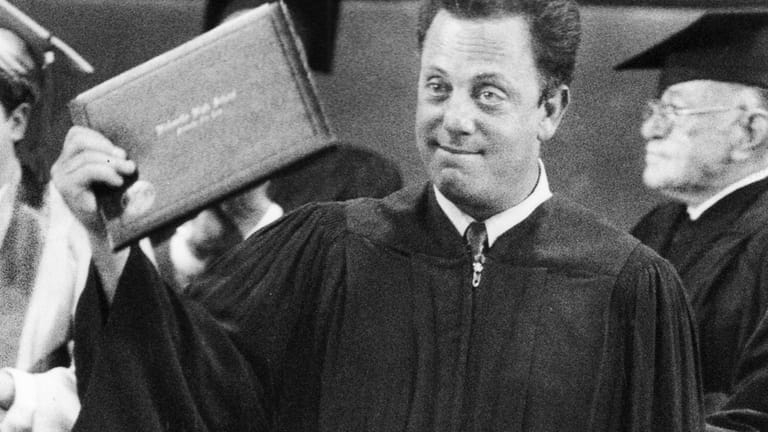 Billy Joel receives his diploma from Hicksville High School on...