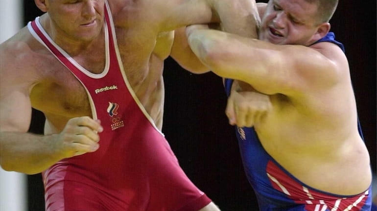 Rulon Gardner, right, of the United States, holds the arm...