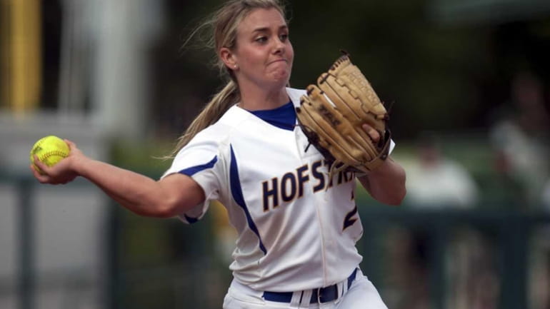 Starting pitcher Olivia Galati throws to first base for an...