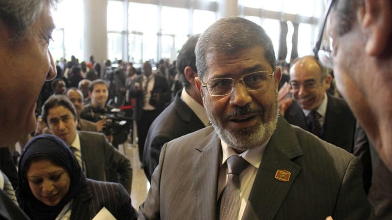 Egypt's newly elected President Mohammed Morsi, center, speaks to delegates...