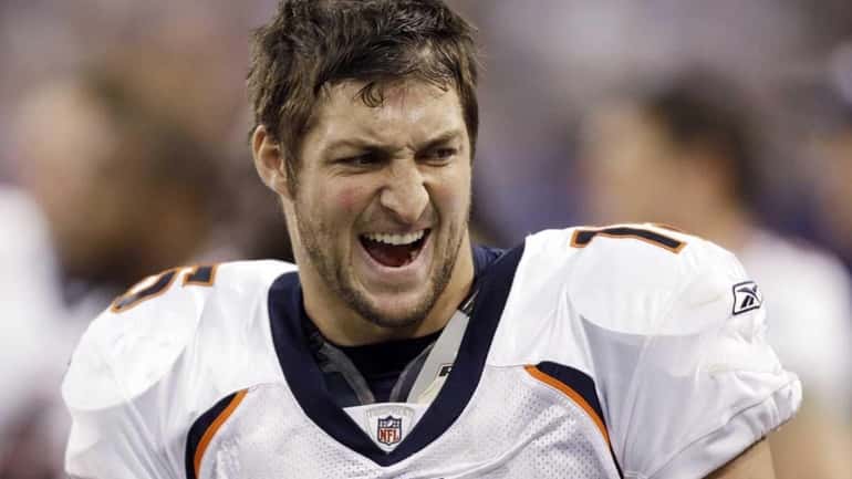 Denver Broncos' Tim Tebow reacts on the bench after a...