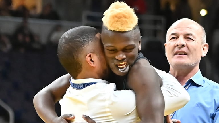 Long Beach’s Dunia Sibomana celebrates with his dad and coach Miguel...