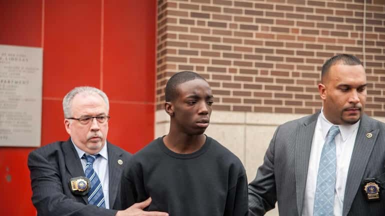 Marcell Dockery, 16, is walked at the 60th Precinct on...