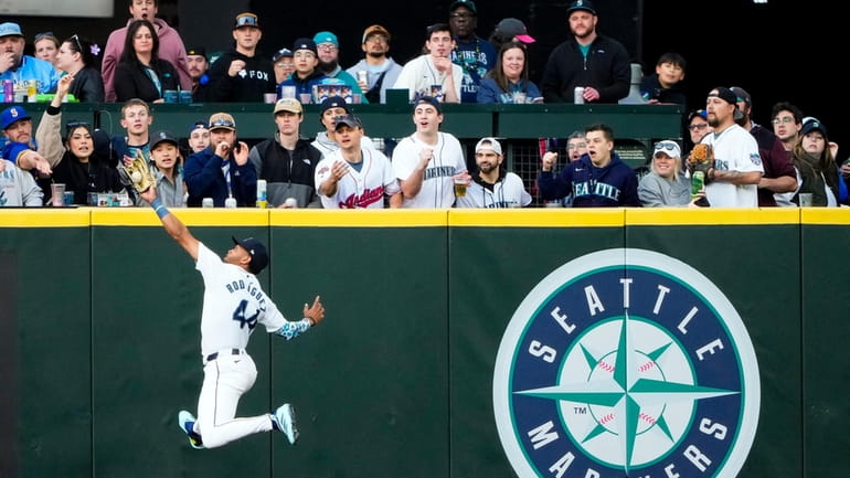 Seattle Mariners center fielder Julio Rodríguez makes a leaping catch...