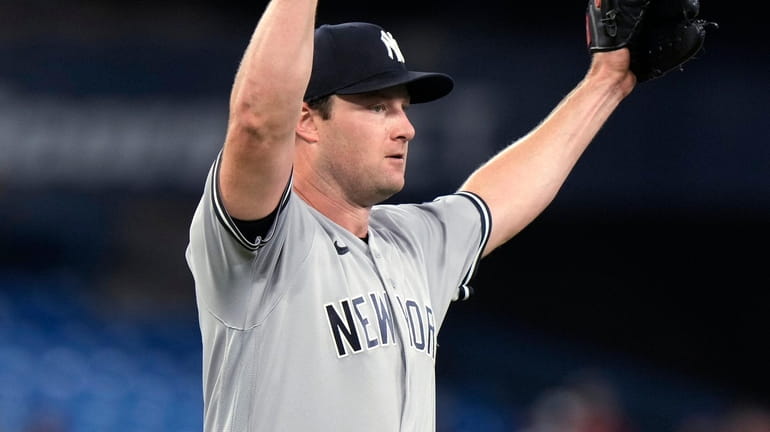 Yankees starting pitcher Gerrit Cole raises his arms after he...
