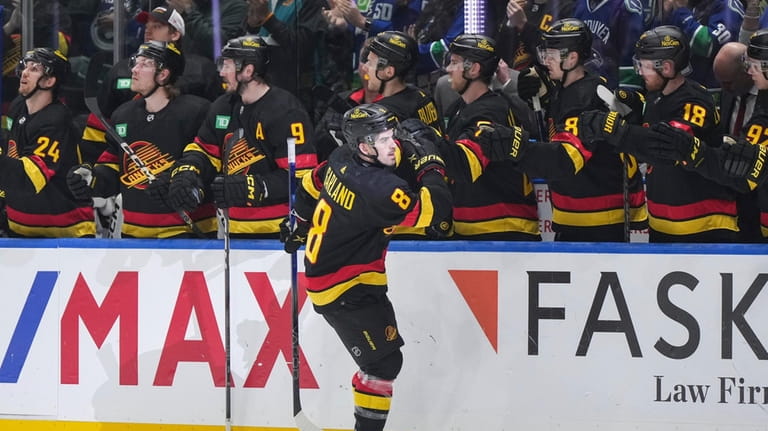 Vancouver Canucks' Conor Garland (8) is congratulated for his goal...