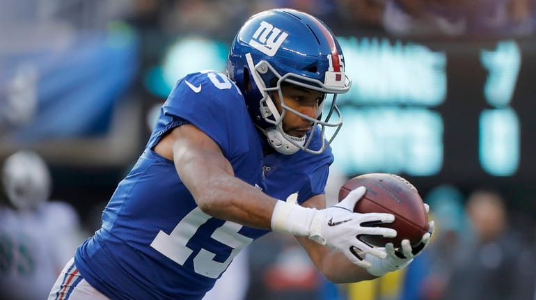 Golden Tate of the Giants hauls in a reception for a...