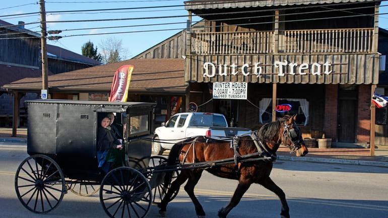 An Amish carriage passes the Dutch Treat restaurant in Spartansburg,...