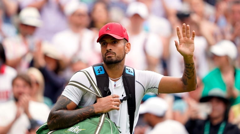 Australia's Nick Kyrgios waves as he walks off court after...