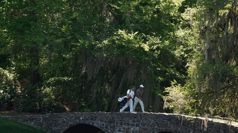 Tiger Woods walks over the Byron Nelson Bridge on the...