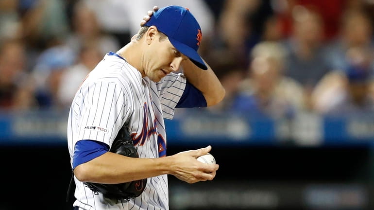 Mets starting pitcher Jacob deGrom reacts on the mound after...