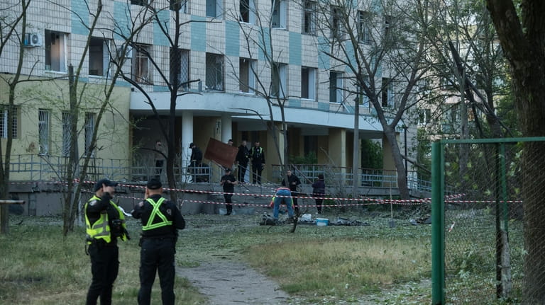 Police inspect a building damaged by a Russian night attack...