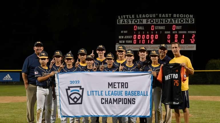 Massapequa Coast Little League holds the championship banner after winning...