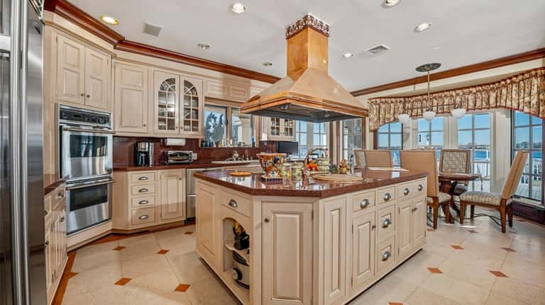 The eat-in-kitchen has a center island, commercial range top and...