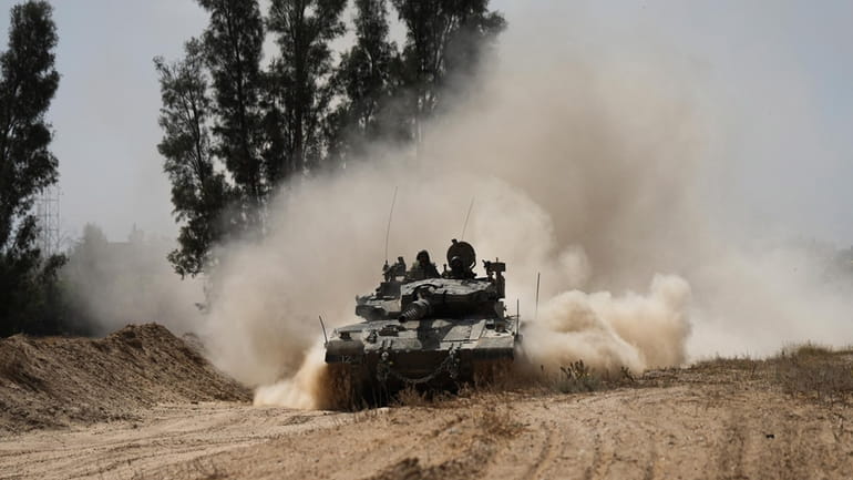 An Israeli tank moves near the Gaza Strip border in...
