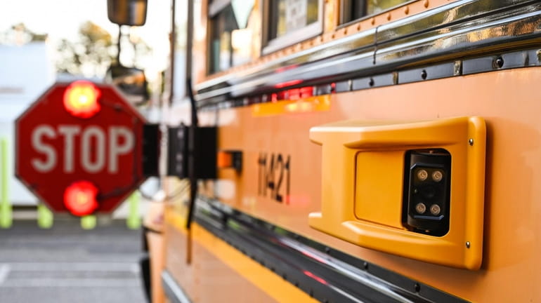A camera is attached to a school bus with flashing...