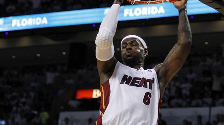 Miami Heat's LeBron James dunks over Boston Celtics' Rajon Rondo...