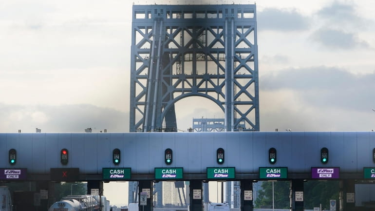 Cars pass through toll booths to use the George Washington...