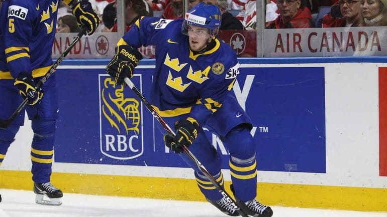 Defenseman Tim Erixon of Sweden carries the puck during the...