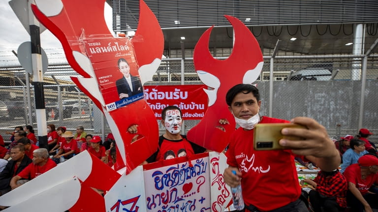 Supporters of Thai ex-Prime Minister Thaksin Shinawatra gather outside Don...