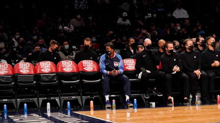 Brooklyn Nets guard Shaquille Harrison, left, sits at the empty...