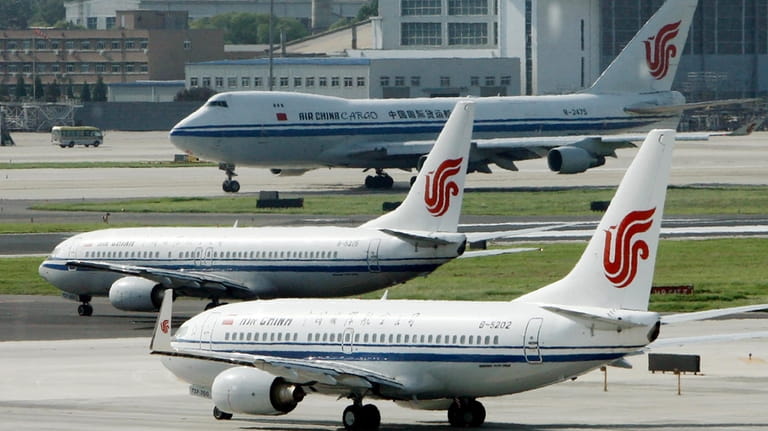 Air China planes sit on the tarmac at Beijing Airport...