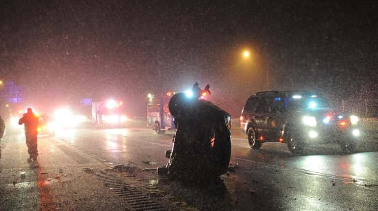 An overturned car sits on the westbound Long Island Expressway...