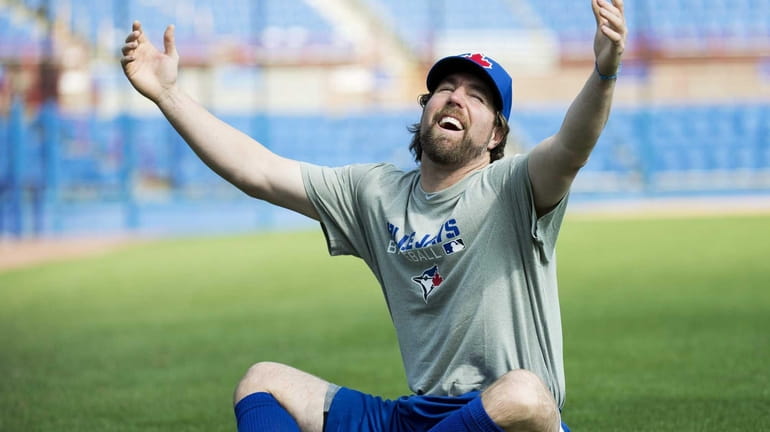 Toronto Blue Jays starting pitcher R.A. Dickey reacts on the...