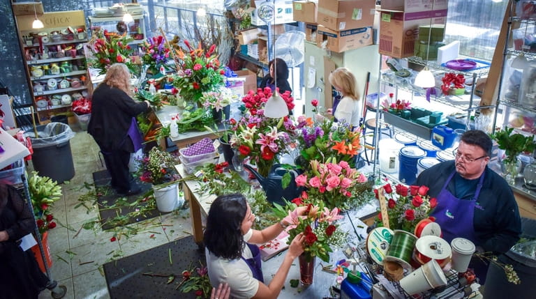 Florists prepare arrangements for Valentines Day at the 1-800-Flowers.com retail...