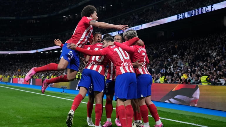 Atletico Madrid's team players celebrate after Marcos Llorente scored their...