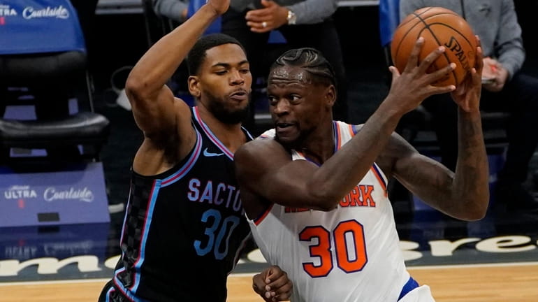 Knicks forward Julius Randle, right, drives to the basket against...