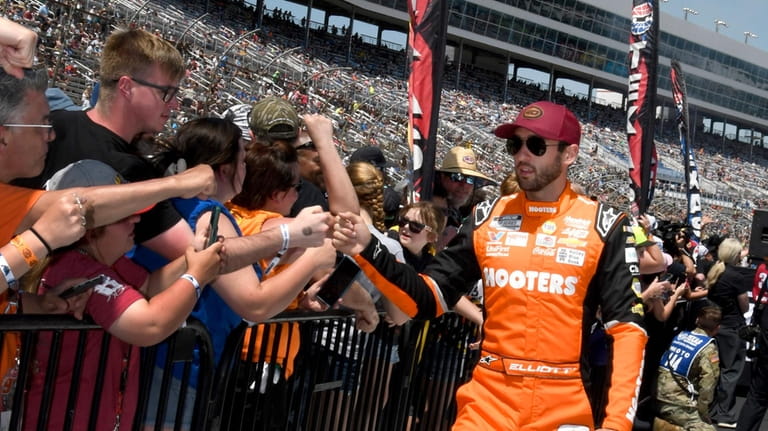 Chase Elliott, right, greets fans during driver introductions before a...
