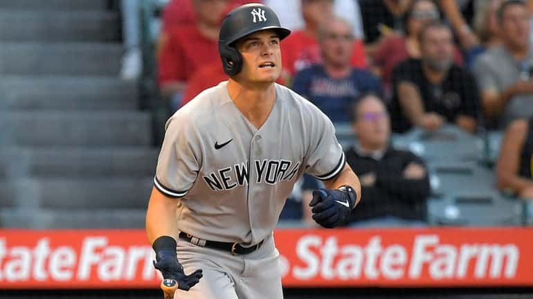 Yankees' Andrew Benintendi heads to first as he hits a...