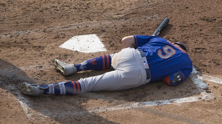 Mets' Brandon Nimmo lays on the ground after an injury...
