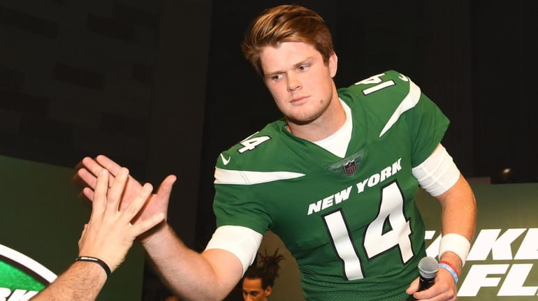 New York Jets quarterback Sam Darnold slaps five wearing the...