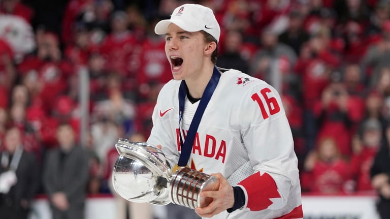 Canada's Connor Bedard carries the Championship Cup after Canada defeated...