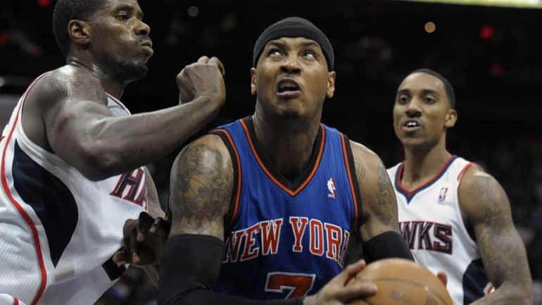 New York Knicks forward Carmelo Anthony, center, looks to the...