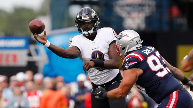 Baltimore Ravens quarterback Lamar Jackson (8) passes under pressure from...