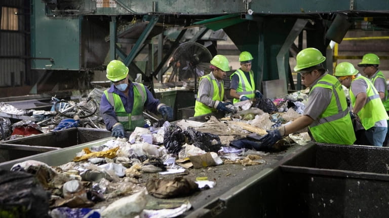 Workers sort commercial recycled material at the Winter Bros. recycling...