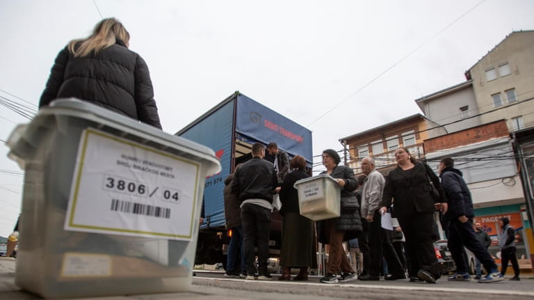 Kosovo election officials unload the ballot boxes and polling station...