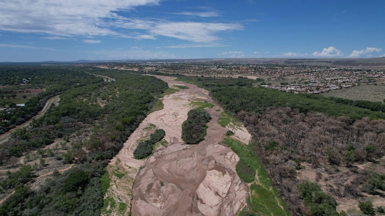 The dry Rio Grande riverbed is seen from the air,...