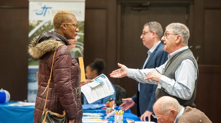 An attendee speaks with a recruiter at a job fair hosted...