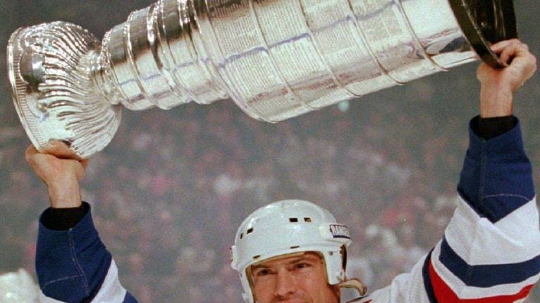 New York Rangers captain Mark Messier lifts the Stanley Cup...