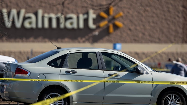 Crime scene tape surrounds a car at the scene of...