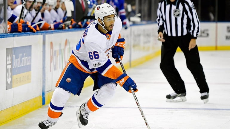 Josh Ho-Sang of the Islanders control the puck against the...