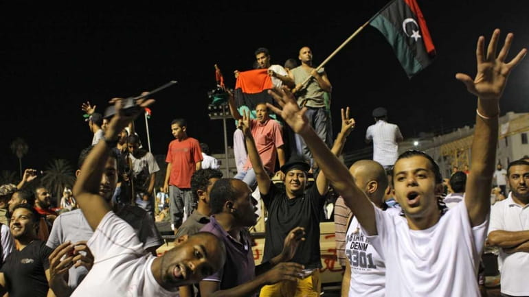 Libyans celebrate overrunning Moammar Gadhafi's compound in Tripoli, Libya, early...