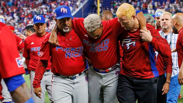 Puerto Rico pitcher Edwin Diaz is helped by team pitching coach...
