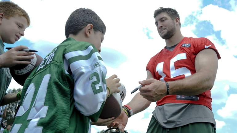 New York Jets quarterback Tim Tebow #15 signs autographs for...